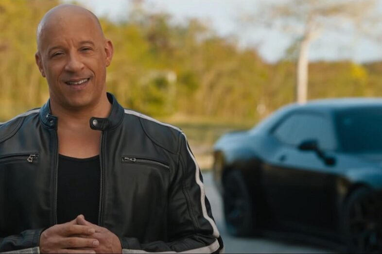 Vin Diesel, having driving a muscle car out to the middle of nowhere, addresses a camera